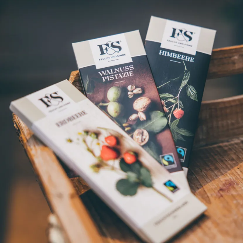 Drei Verpackungen von Jodl Packaging mit Geschmacksrichtungen Walnuss Pistazie, Himbeere und Erdbeere, im eleganten Design.